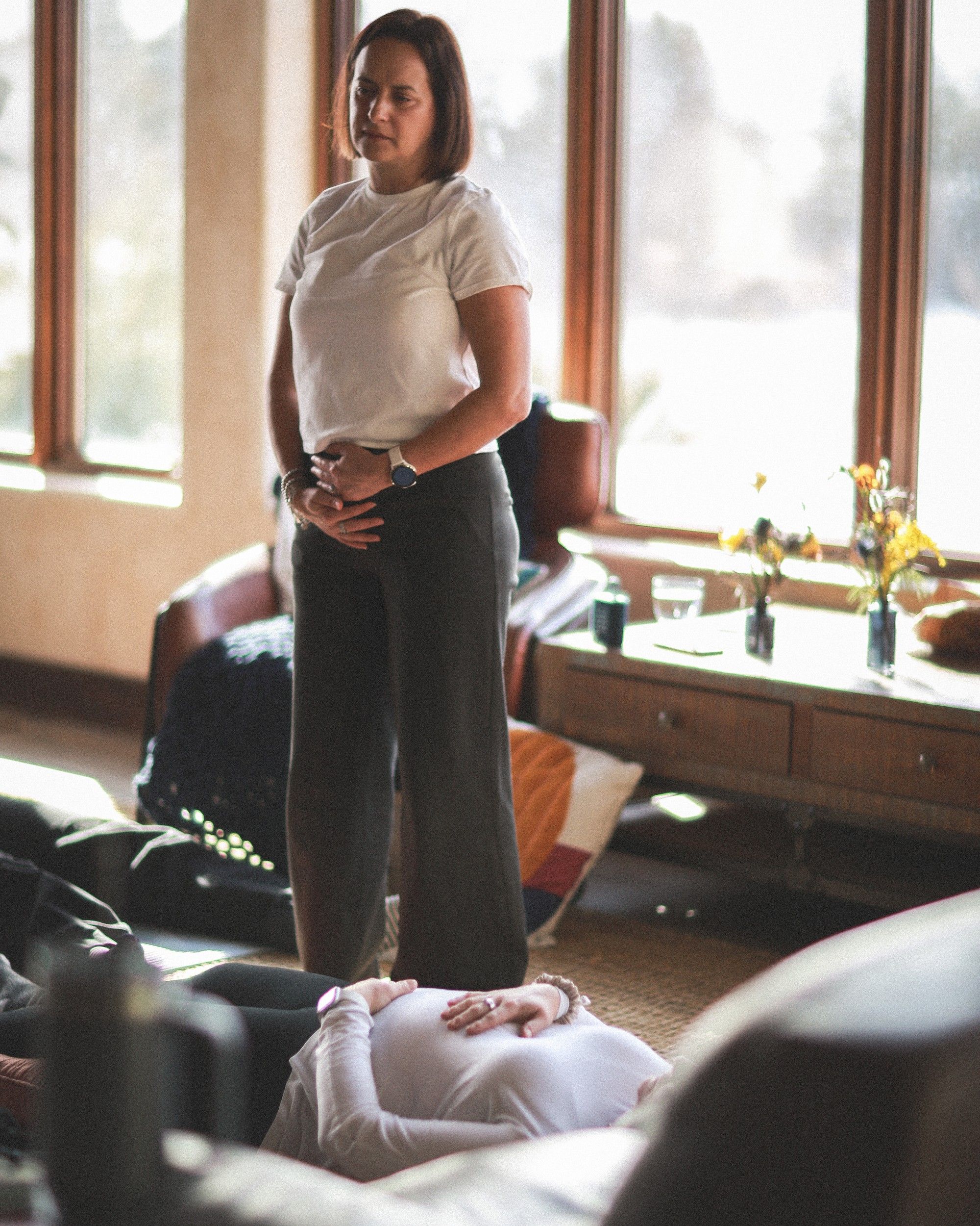 Louise standing calmly as she guides a client through a breathing exercise