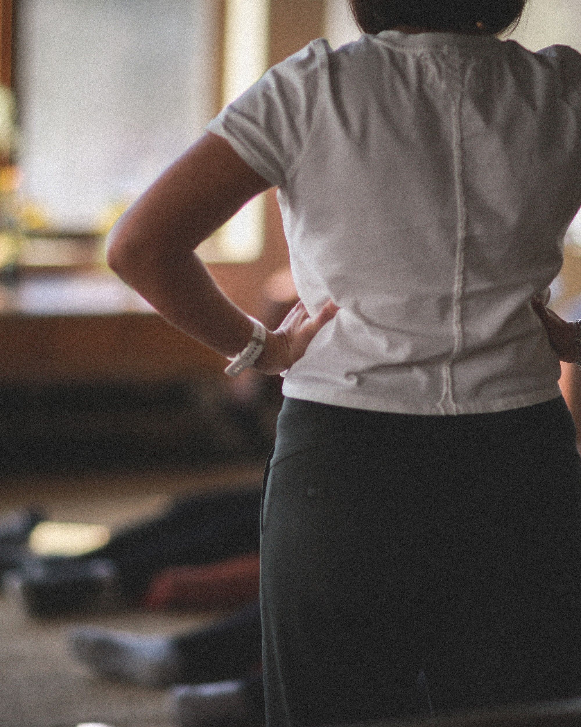 Seen from behind, Louise leads a group breathing session while participants rest on mats