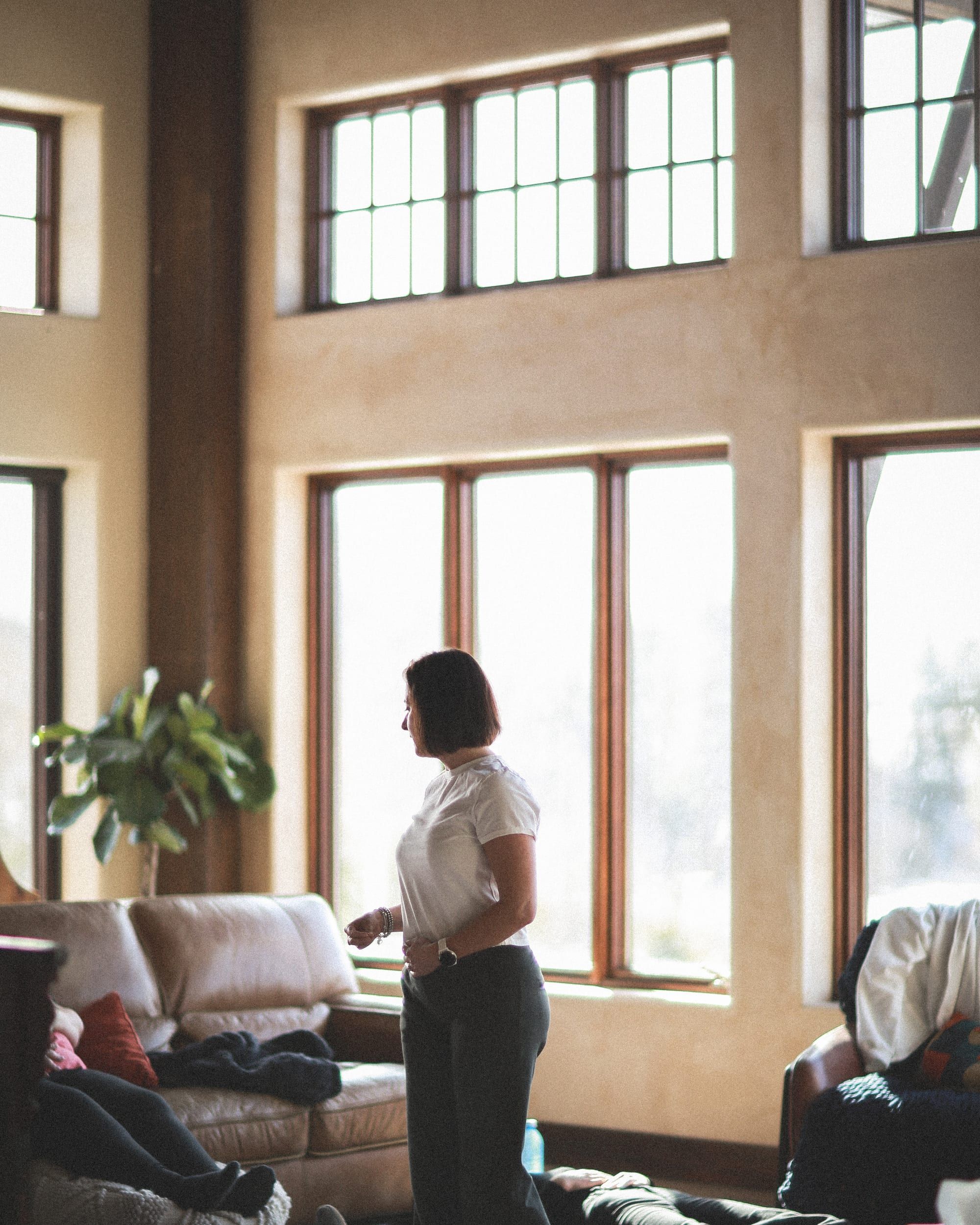 Louise guiding a resting breathing session in a calm, light-filled room with tall windows