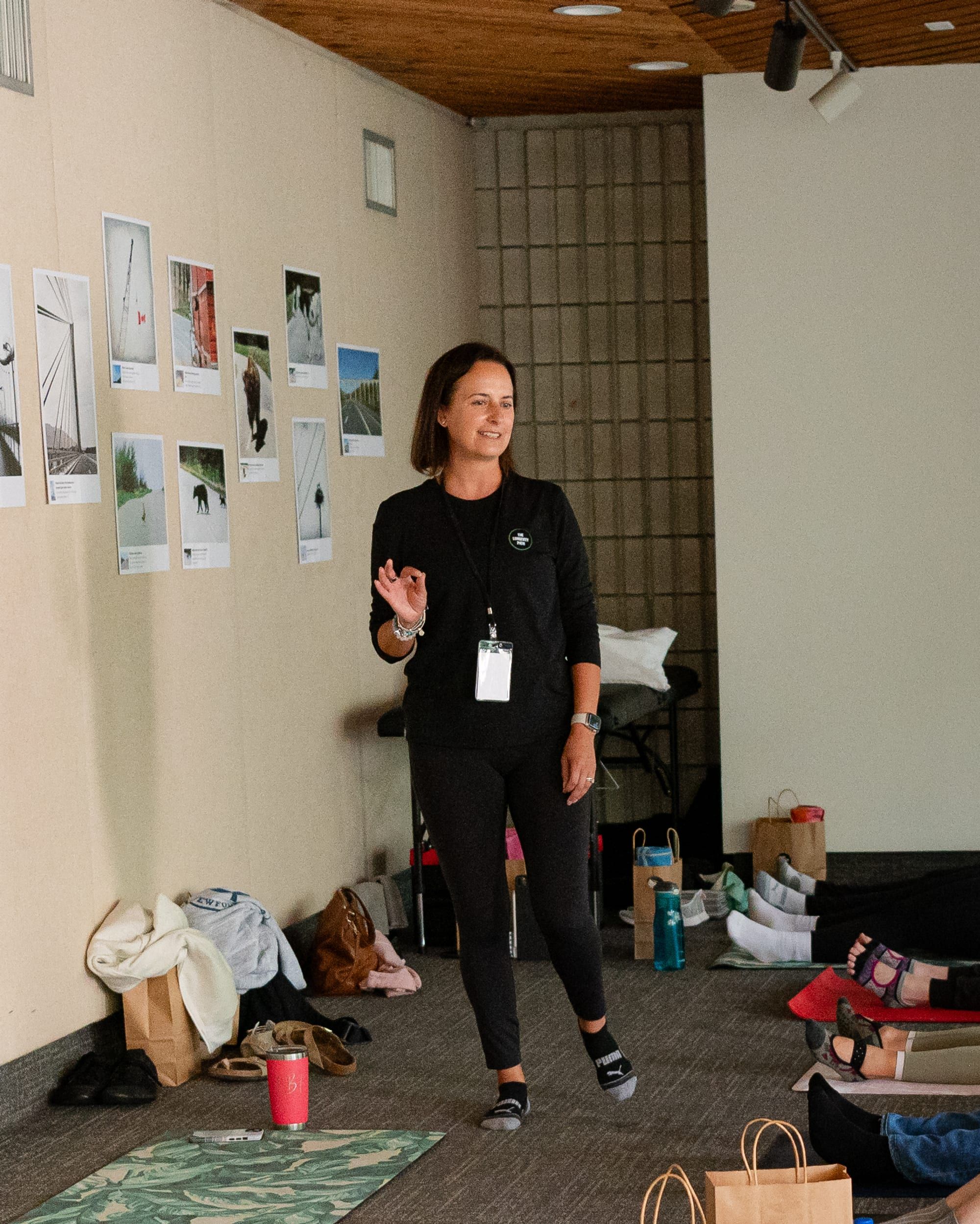 Louise Brans Fitzgibbon standing and coaching a group breathing session, participants lying on mats around her
