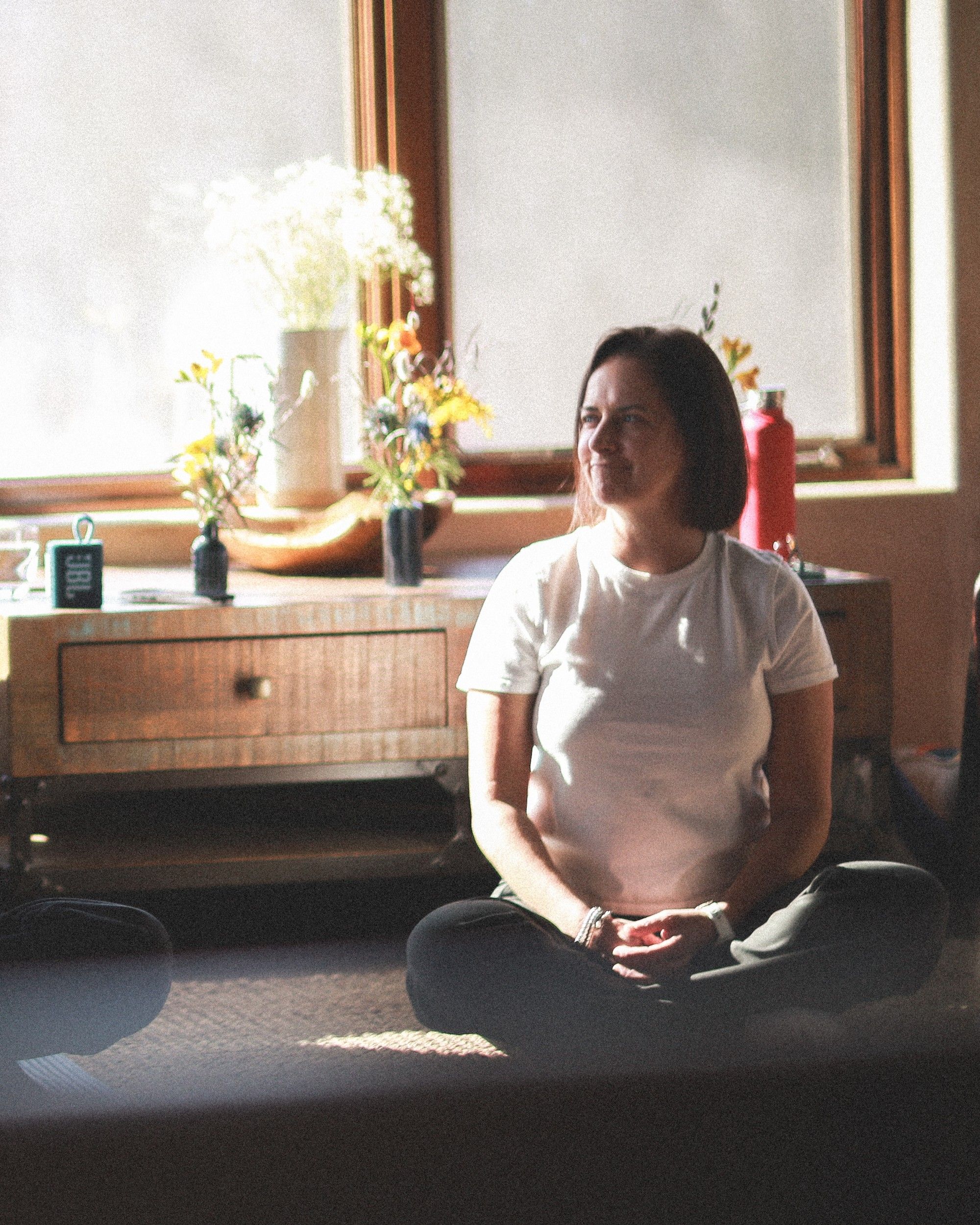 Louise seated by a bright window, at ease